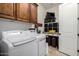 Functional laundry room featuring washer, dryer, overhead storage cabinets, and labeled storage baskets at 12834 W Forest Pleasant Pl, Peoria, AZ 85383