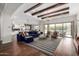 Open-concept living room with exposed wood beams, seamlessly connected to the kitchen and offering a view of the backyard pool at 12834 W Forest Pleasant Pl, Peoria, AZ 85383