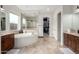 Luxurious bathroom featuring a tub, walk-in shower with glass door and dual sink vanity at 12834 W Forest Pleasant Pl, Peoria, AZ 85383