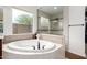 Bright and airy bathroom featuring a tub, a large window, and a walk-in shower at 12834 W Forest Pleasant Pl, Peoria, AZ 85383