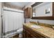 Stylish bathroom featuring a granite vanity, framed mirror, and tiled walls in neutral tones at 1408 N 62Nd Pl, Mesa, AZ 85205