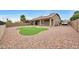 Landscaped backyard featuring an artificial grass area, gravel, covered patio, and a secure fence at 16039 W Pima St, Goodyear, AZ 85338
