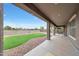 View of the backyard with an artificial lawn, gravel, string lights, and covered patio at 16039 W Pima St, Goodyear, AZ 85338
