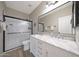 Updated bathroom featuring a double sink vanity, a large mirror, and a tiled shower at 16039 W Pima St, Goodyear, AZ 85338