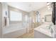 Bright bathroom with double sinks, soaking tub, walk-in shower, and modern fixtures at 16039 W Pima St, Goodyear, AZ 85338