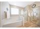 Bathroom featuring a tub, shower, white subway tiles, and light wood floors at 16039 W Pima St, Goodyear, AZ 85338