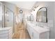 Elegant bathroom featuring double sinks, a marble countertop, and a glass shower at 16039 W Pima St, Goodyear, AZ 85338