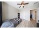Neutral bedroom with light hardwood floors, ceiling fan, and closet with sliding doors at 16039 W Pima St, Goodyear, AZ 85338