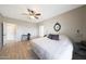Bright bedroom with wood floors, ceiling fan, neutral walls, and a quaint desk area at 16039 W Pima St, Goodyear, AZ 85338