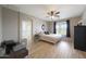 Light-filled bedroom boasting a ceiling fan, wood floors, and ensuite bathroom at 16039 W Pima St, Goodyear, AZ 85338