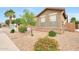 Attractive front of house with desert landscaping and pops of color from mature flowering bushes at 16039 W Pima St, Goodyear, AZ 85338