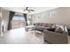 Bright living room with wood floors, ceiling fan, fireplace, and sliding glass doors to backyard at 16039 W Pima St, Goodyear, AZ 85338