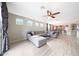 Expansive living room featuring a ceiling fan, wood floors, and view into the kitchen at 16039 W Pima St, Goodyear, AZ 85338