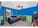 Bright bedroom with blue and green walls, complemented by a ceiling fan and a cozy black daybed at 16139 N 171St Ln, Surprise, AZ 85388