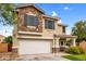 Attractive two-story house featuring a stone accent wall, white garage door, and covered porch at 16139 N 171St Ln, Surprise, AZ 85388