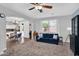 The cozy living room has an open floor plan, lots of light, plush carpet and an archway to the kitchen at 16139 N 171St Ln, Surprise, AZ 85388