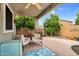 Charming covered patio with comfortable seating, lush greenery, and a view of the backyard at 16139 N 171St Ln, Surprise, AZ 85388