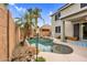 Beautiful backyard pool area with lush greenery, rock features, and a view of the home's exterior at 16139 N 171St Ln, Surprise, AZ 85388