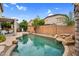 Serene backyard oasis featuring a sparkling pool, lush landscaping, and a covered patio with seating at 16139 N 171St Ln, Surprise, AZ 85388