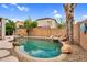 Inviting backyard pool with stone accents and surrounding mature landscaping, creating a private oasis at 16139 N 171St Ln, Surprise, AZ 85388
