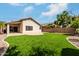 Enjoy the backyard featuring lush artificial turf, a covered patio, and desert-friendly landscaping at 16424 S 46Th Way, Phoenix, AZ 85048