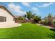 A relaxing artificial grass backyard and patio surrounded by lush landscaping and privacy walls at 16424 S 46Th Way, Phoenix, AZ 85048