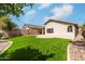 Green artificial turf backyard with a patio, rock beds, and block fence with mature landscaping at 16424 S 46Th Way, Phoenix, AZ 85048
