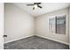 Cozy bedroom with a bright window, ceiling fan, and neutral colored carpet flooring at 16424 S 46Th Way, Phoenix, AZ 85048