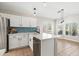 Modern kitchen featuring white cabinets, blue tile backsplash, stainless steel appliances, and a center island with bar seating at 16424 S 46Th Way, Phoenix, AZ 85048