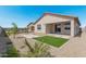 Charming backyard with desert landscaping, featuring a patch of green grass and stepping stones at 18247 W Soft Wind Dr, Surprise, AZ 85387