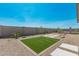 Spacious backyard featuring a patch of green grass, xeriscaping, and tall block fencing for privacy at 18247 W Soft Wind Dr, Surprise, AZ 85387
