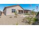 Exterior view of home with desert landscaping, an American flag, and a manicured backyard at 18247 W Soft Wind Dr, Surprise, AZ 85387