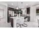 Stylish kitchen features a breakfast bar, stainless steel appliances, and dark cabinets with modern fixtures at 18247 W Soft Wind Dr, Surprise, AZ 85387