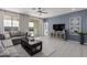 Comfortable living room featuring a large sofa, TV, and stylish decor, adjacent to the outdoor patio at 18247 W Soft Wind Dr, Surprise, AZ 85387