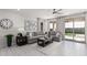 Open-concept living room with a large sectional sofa, tile flooring, and access to the outdoor patio at 18247 W Soft Wind Dr, Surprise, AZ 85387