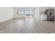 Spacious living room featuring light wood-look floors, a sliding glass door, and a connection to the kitchen at 18795 E Bruno Dr, Gold Canyon, AZ 85118