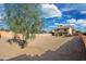Wide backyard featuring a young shade tree and view of the house with second story balcony at 22074 W Papago St, Buckeye, AZ 85326
