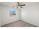 Bedroom with ceiling fan and a window offering a view of a neighboring roof and blue sky at 22074 W Papago St, Buckeye, AZ 85326
