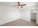 Bedroom features neutral carpet, a ceiling fan, closet, and a door at 22074 W Papago St, Buckeye, AZ 85326