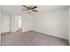 Bedroom with carpet and ceiling fan, with a view into the bathroom at 22074 W Papago St, Buckeye, AZ 85326