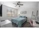 Comfortable bedroom features a ceiling fan, work space and cozy bed with plush blue accents at 23018 E Mewes Rd, Queen Creek, AZ 85142