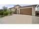 Charming home with a two-car garage, beautiful stone accents, and a well-maintained driveway at 23018 E Mewes Rd, Queen Creek, AZ 85142
