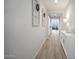 Bright hallway features wood-look tile floors, white walls, and decorative window frame art at 23018 E Mewes Rd, Queen Creek, AZ 85142