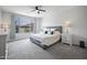 Inviting main bedroom with a large window and plush carpeting, a ceiling fan and modern décor at 23018 E Mewes Rd, Queen Creek, AZ 85142