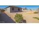 The gravel backyard has a small patio, block wall, and desert landscaping at 24627 W Ripple Rd, Buckeye, AZ 85326