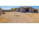 Gravel backyard features a small patio, block wall, and desert landscaping at 24627 W Ripple Rd, Buckeye, AZ 85326