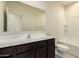This bathroom has a sink, mirror, toilet and shower/tub combo with a light-colored walls at 24627 W Ripple Rd, Buckeye, AZ 85326