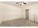 This bedroom features neutral carpet, a ceiling fan, and doors leading to other rooms at 24627 W Ripple Rd, Buckeye, AZ 85326