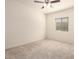 This bedroom features neutral carpet, a ceiling fan, window and light-colored walls at 24627 W Ripple Rd, Buckeye, AZ 85326