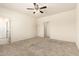 Neutral bedroom with a ceiling fan, carpet flooring, and access to an ensuite bathroom at 24627 W Ripple Rd, Buckeye, AZ 85326